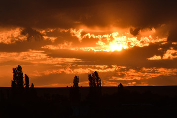 Dramatic sunset with orange sky and clouds during summer time