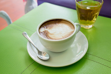 Hot Cappuccino Coffee cup on the wood table in shop