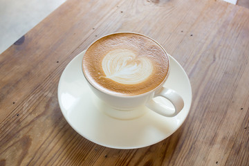 Hot Cappuccino Coffee cup on the wood table in shop