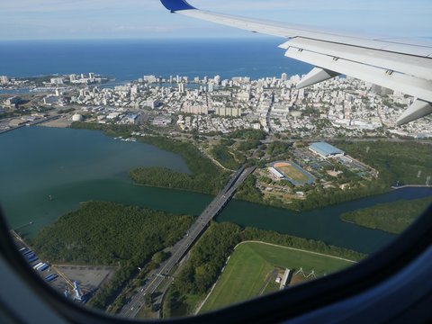 Aerial view of San Juan and the tip of the Puerto Rico International Airport, seen from an airplane window.
