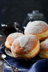 Fresh baked berliner with custard on a dark concrete background. German donats. Selective focus.