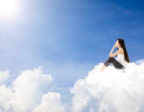 young woman  sitting on cloud and dreaming concept