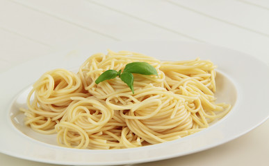 Spaghetti pasta with basil herbs. White background. Close up view.