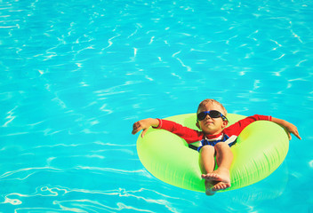 little boy in floating ring having fun on beach