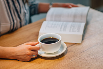 Woman drinking coffee and reading book