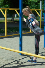 Obraz premium A sweet girl is doing exercises. A young girl kneads in the morning on the street. The gymnast trains in the park.