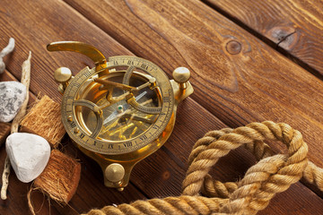 Compass and rope on wooden table. close up