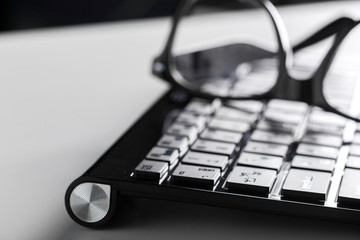 eyeglasses and keyboard on the table