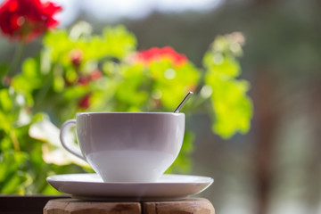 white cup on background flowers  outdoor