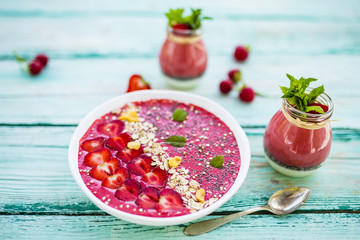 A bowl of healthy and delicious strawberry smoothie with grains and fresh fruit. 