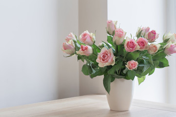 pink roses in vase on white background