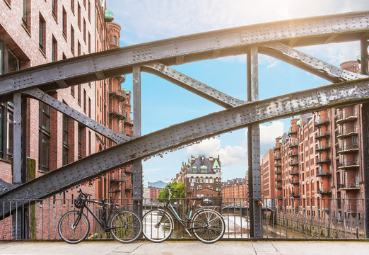 bicycles parked against iron handrail on a bridge in the old warehouse district Speicherstadt in Hamburg, Germany