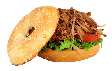 Slow cooked shredded beef and salad filled bagel sandwich isolated on a white background
