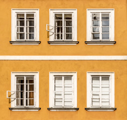 Fototapeta na wymiar Six windows in two rows with white frames. Building is of orange color situated in Prague.