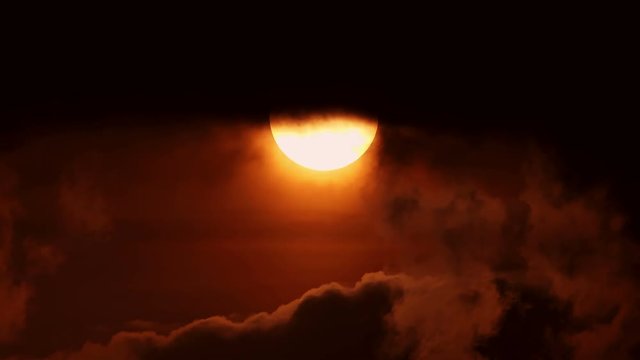 Big sun disk in sunset in cloudy sky timelapse. horror and terror background. ecology and pollution concept. Red moon. Wolf Night background. red smoky sky with a big red sun.