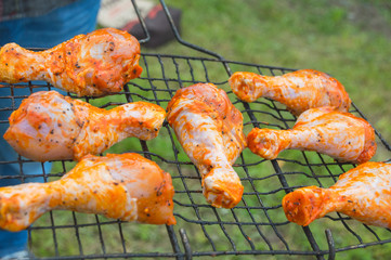 in the hands of men grill with chicken legs.
