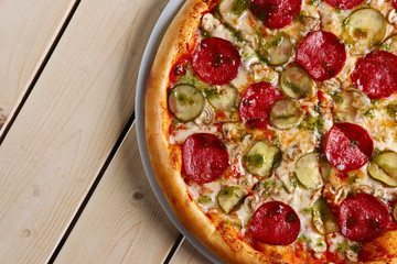 Top view of piece of pizza with sausage, cucumber and mushrooms