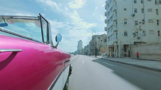 Cuban chauffeur driving through Habana, Cuba.