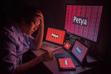 Young Asian male frustrated, confused and headache by Petrwrap or Petya ransomware attack on...