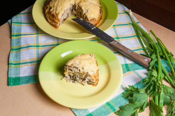 Piece of pancakes pie with mushrooms and chicken meat on green plate. Traditional meal for Maslenitsa - Russian pancake week..