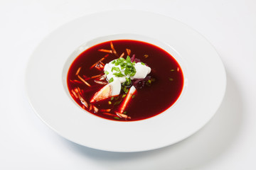 tomato soup with beetroot closeup horizontal on a white background
