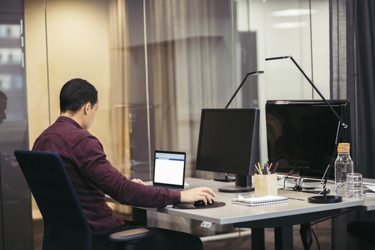 Businessman working on laptop at desk in office