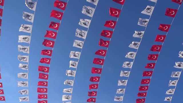 4K Small Turkish pennants with Ataturk picture against the bue sky on the wind