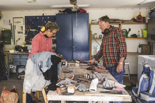 Senior couple standing at workbench in workshop