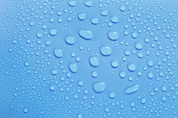 Fototapeta na wymiar Water drops on smooth surface, blue background