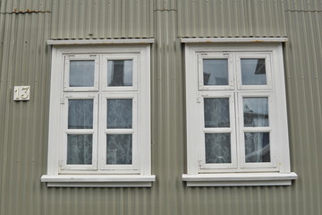 Typical Icelandic house facade in gray color made of corrugated iron and with white wooden windows in Reykjavik (the capital city of Iceland) 