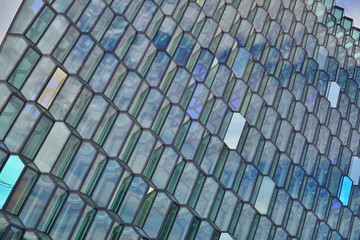 Abstract pattern made of glass wall with detail in the shapes of dark and bright hexagonal cells 