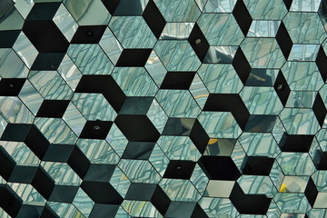 Abstract pattern made of glass wall with detail in the shapes of dark and bright hexagonal cells 