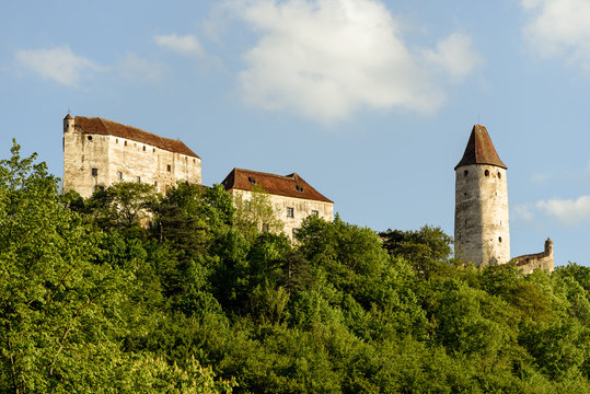 Outdoor scenic color photography of the medieval castle Seebenstein, Austria, located on a hill with a green forest taken on a sunny spring day with blue sky and some clouds