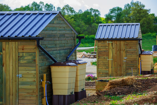 Green Recovery Of Rainwater Outside In Town Garden With Small Wooden Cabin