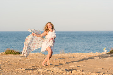 Fototapeta na wymiar Young woman dancing with long scarf