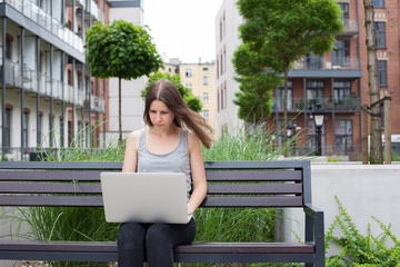 Young woman freelancer works with new silver laptop