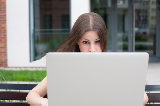 Young woman freelancer works with new silver laptop