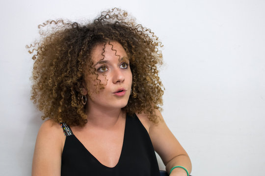Giovane ragazza con i capelli ricci parla