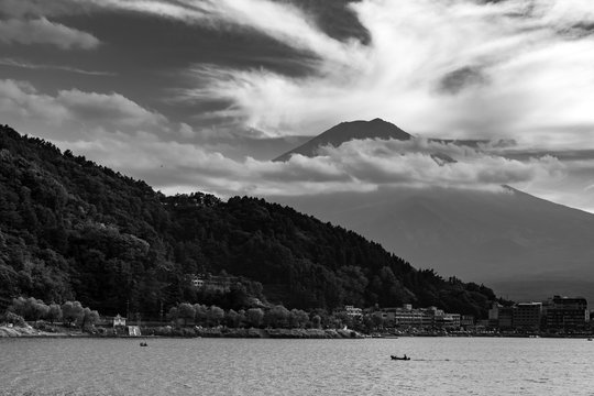 Black and white photo of the mountain Fudji captured across the large lake in Japan