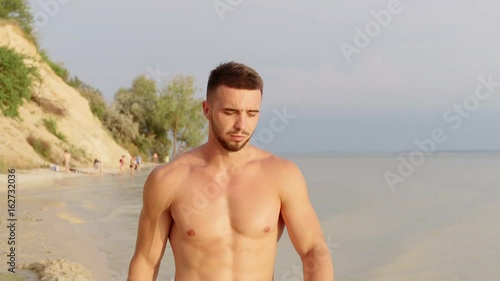 Slow Motion: Young Half Naked Man Walk Along The Beach In 