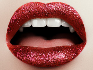 Glamour fashion bright red lips make-up with glitter. Macro of woman's face part. Sexy glossy lip makeup, luxury lady