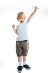 little kid boy showing gesture of success and holding wooden stick isolated on white