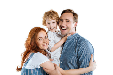 Happy family with one child hugging and smiling at camera isolated on white