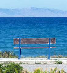 Old wooden bench overlooking the sea and mountains