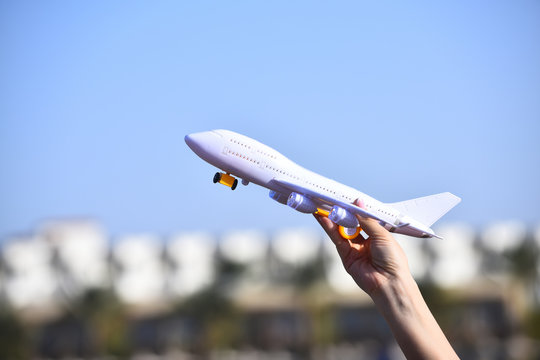 White airliner toy model in female hand