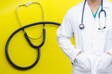 smart doctor with a stethoscope around his neck with stethoscope on yellow background, heart health care and medical technology concept, selective focus, copy space