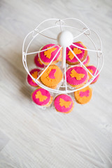Cupcake colorati rosa e arancioni con decorazione farfalla, posizionati su giostra carillon, decorazioni compleanno eventi