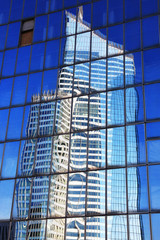 Fototapeta na wymiar Reflection of a skyscraper in glass office windows