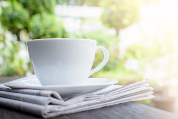 coffee cup clock and news paper on old wooden table nature background