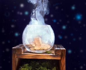glass vase of a piggy bank with a pile of coins with smoke against a starry sky. © urika